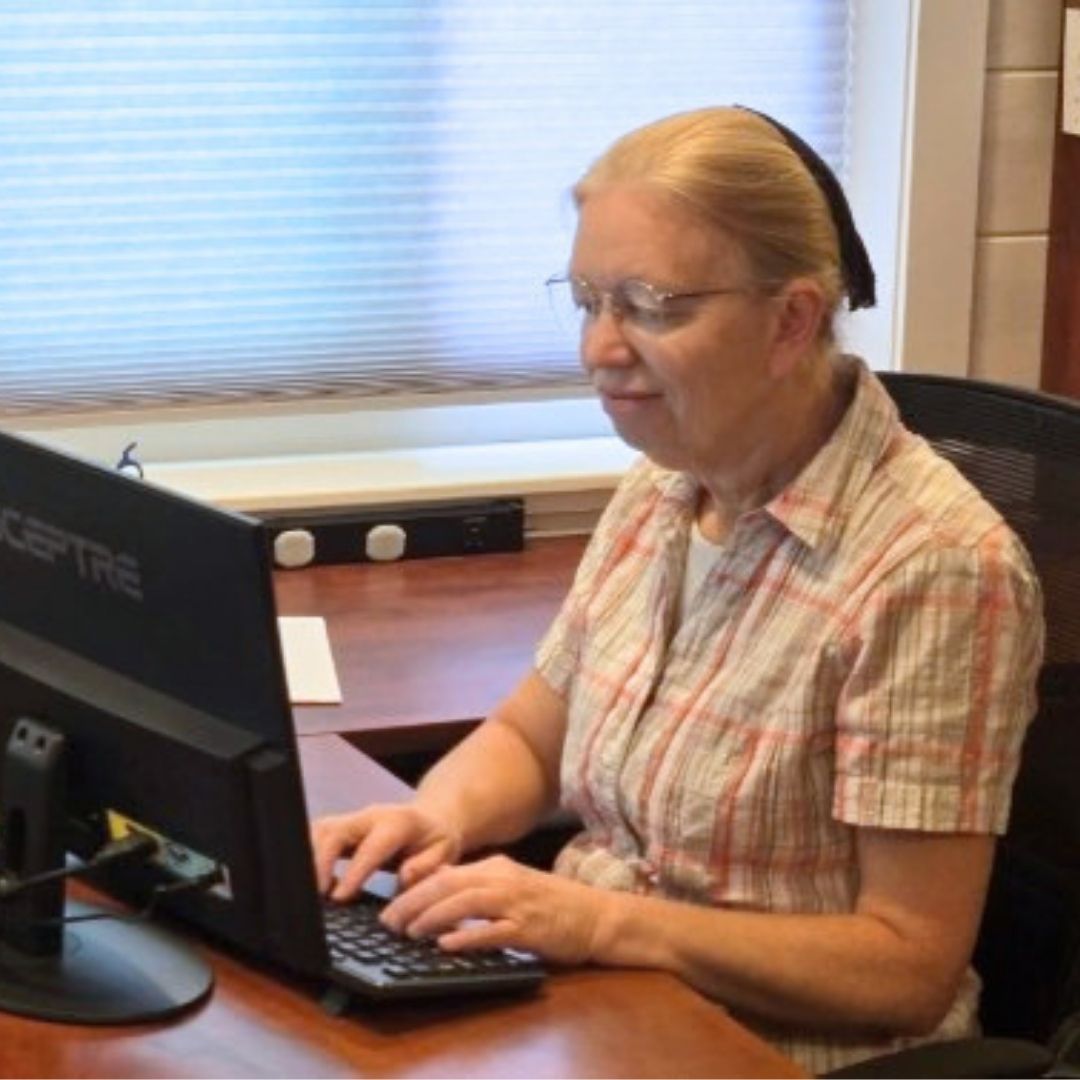 Ann Schrag typing at her computer