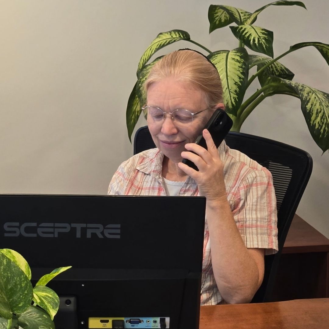 Ann Schrag talking on the phone at her desk