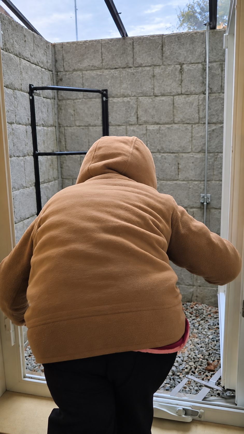 Five-year-old girl climbing out of a basement egress window into an Illumicast window well during a family fire drill