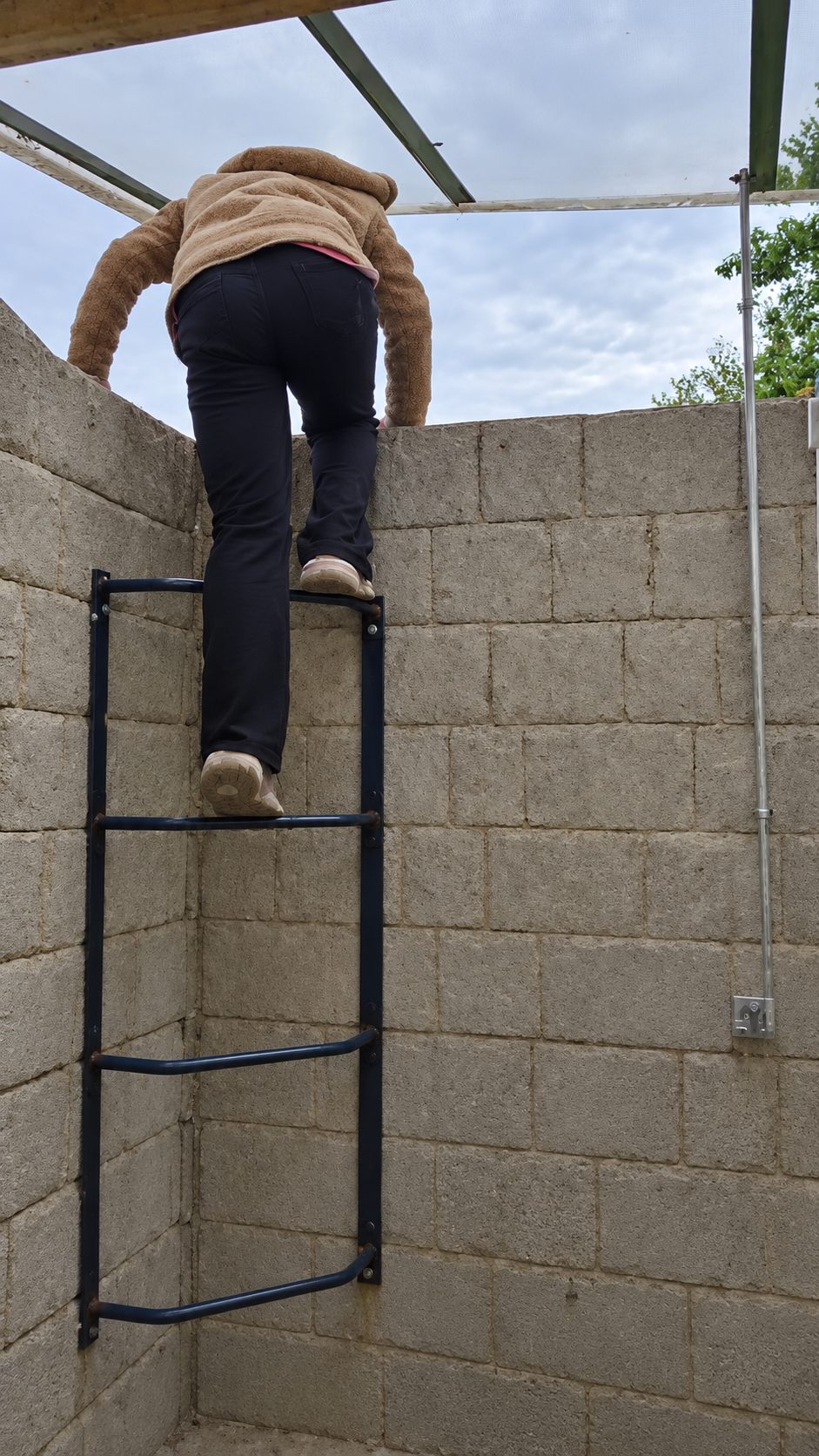 Child climbing the egress window well ladder to escape the basement