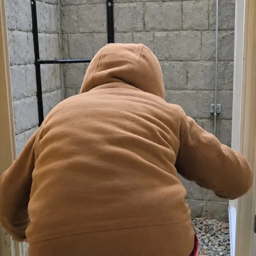 Five-year-old girl climbing out of a basement egress window during a family fire drill